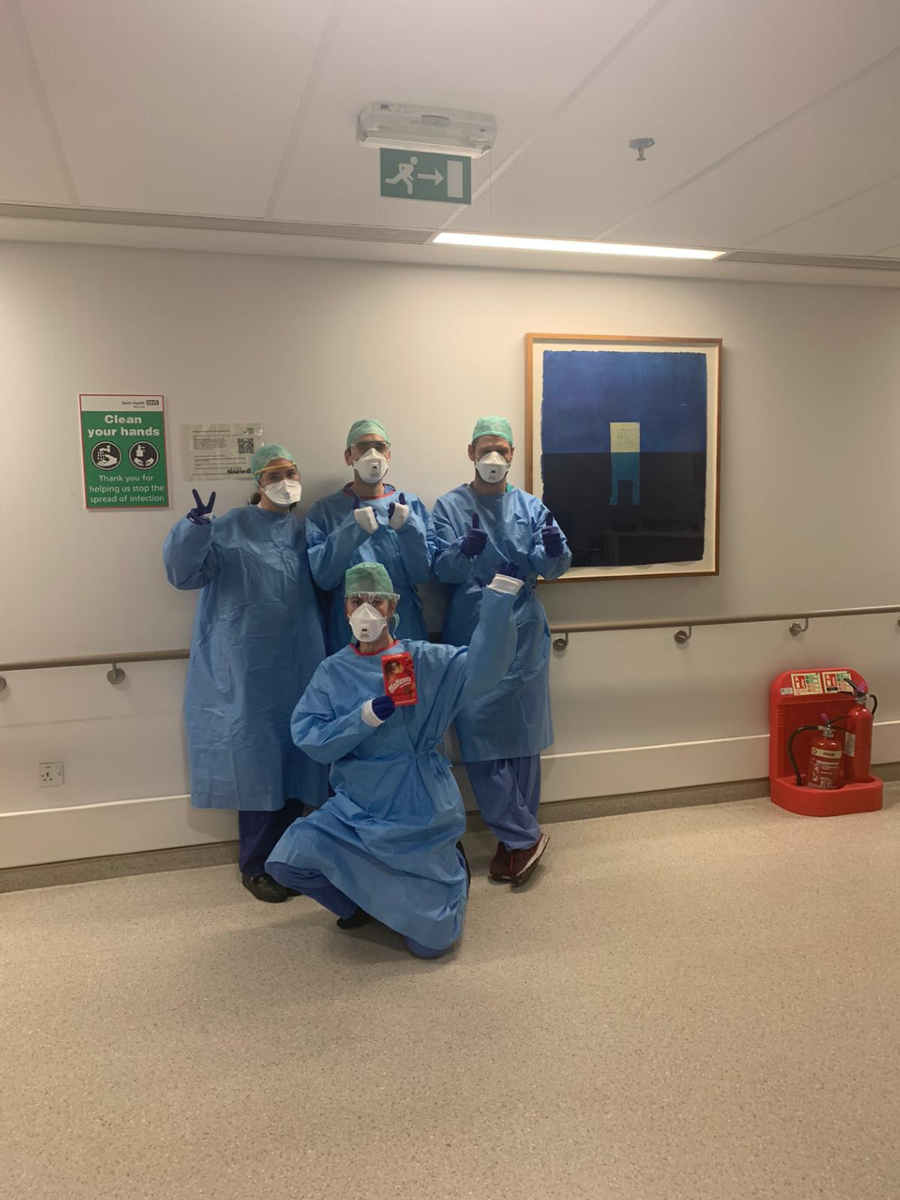 Four respiratory staff members inside a hospital corridor