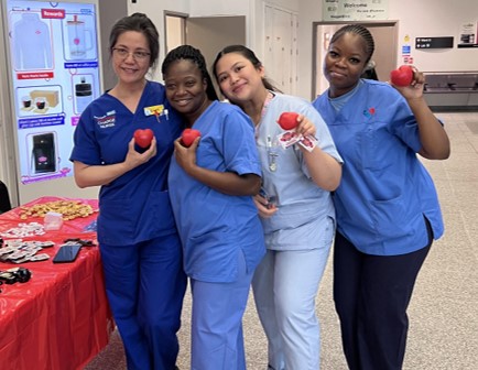 Royal London nurses in scrubs holding heart shaped stress balls at the Barts Hearts launch